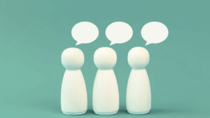 Three white playing pieces used to depict three people on a teal green background.They have speech bubbles above their head to suggest they are getting a second opinion on your Business IT.